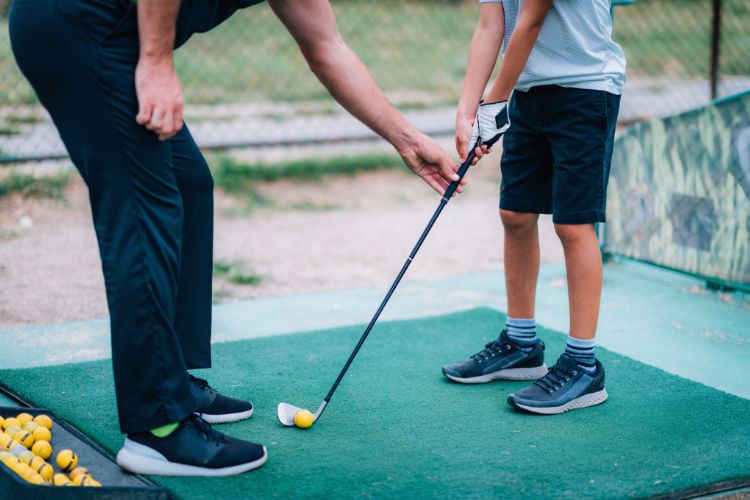 Giving a child a golf lesson.