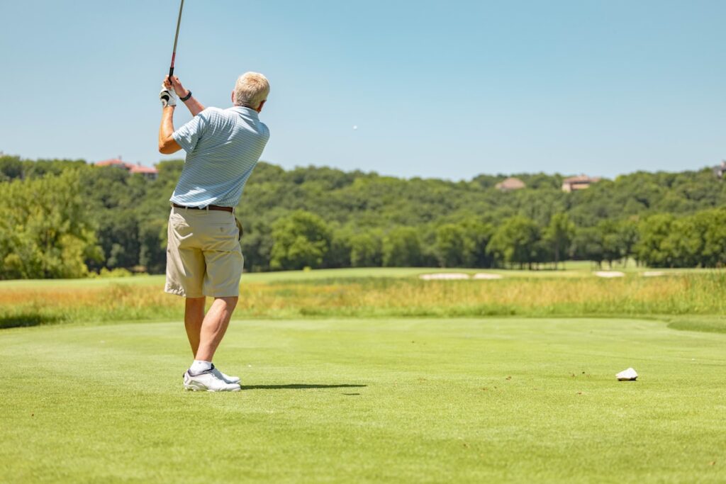Golfer swinging an iron on the fairway