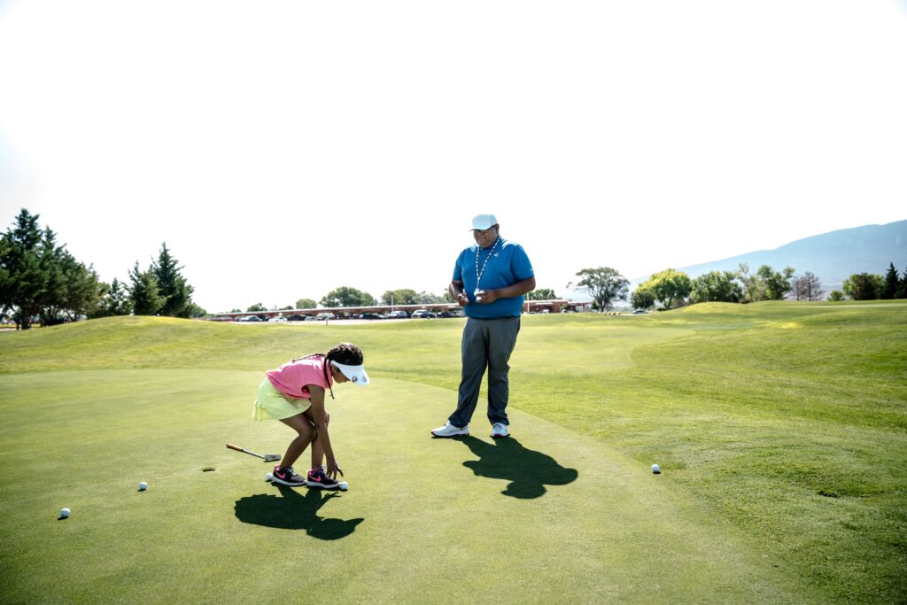 Golf instructor coaching a student on the course