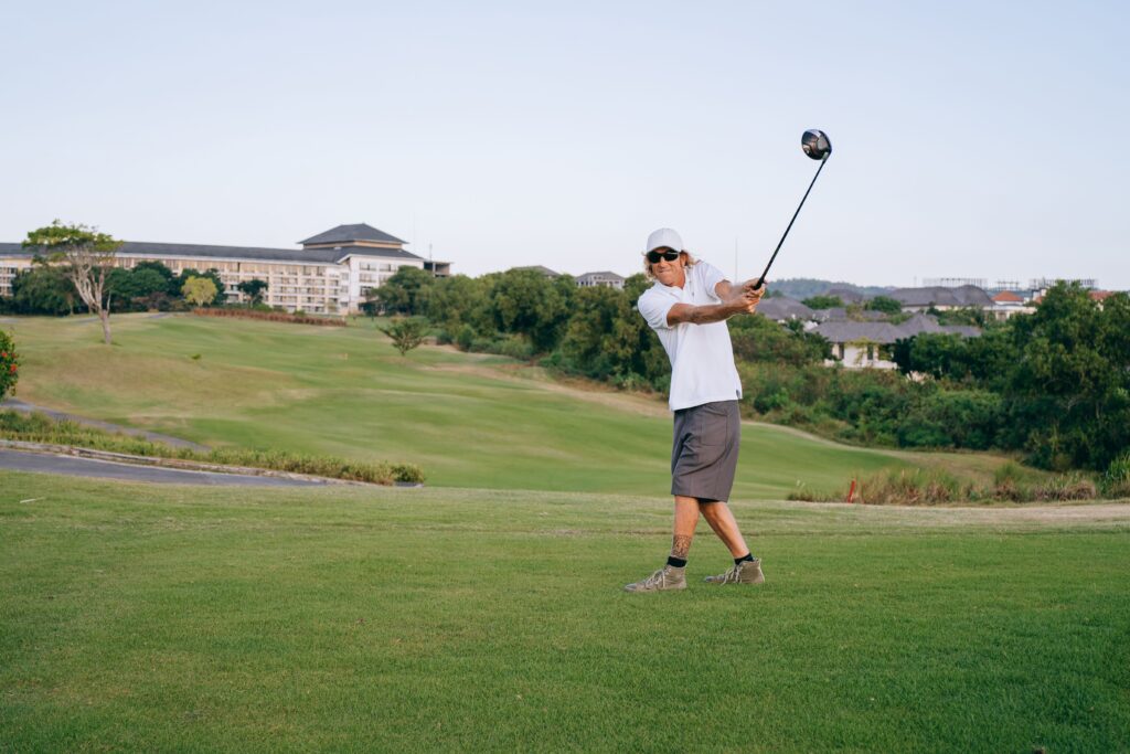 Golfer in follow-through position on a lush green course